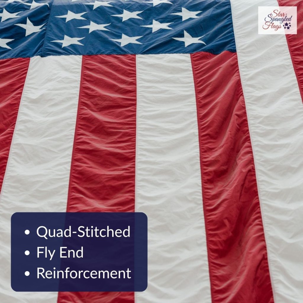 Close-up of an American flag showing reinforced fly-end construction with quadruple stitching for added durability.